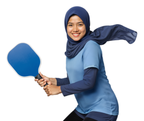 Female pickleball player in hijab smiling while posing with paddle, isolated background