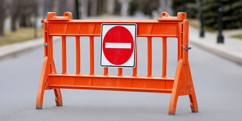 Orange plastic road barrier with a no entry sign blocking access on an empty street, symbolizing restriction and safety