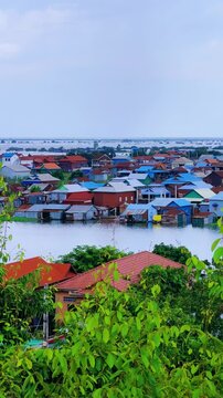 Viewpoint of a flooded fishing village near the Krahom Temple, Cambodia. From the mountain Krahom (Pnom Krom) overlooking the lake Tonlesap. Houses are built on high stilts. Rainy season. 4К