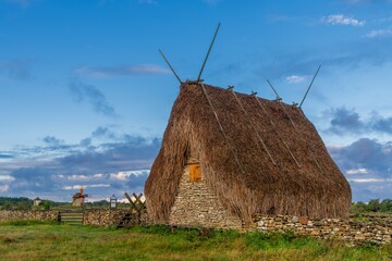 view of the historic Hundslausar stone shed with thatched roof on Gotland Island at sunrise