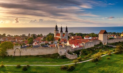 drone cityscape of Visby with the medieval city wall and landmark cathedral at sunset