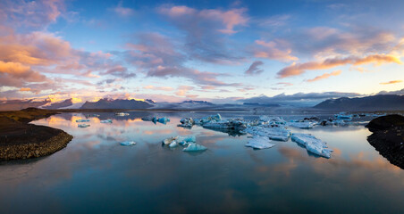 panorama view of the icebergs and the Jokulsarlon Glacier lagoon with Vatnajokull Glacier in the background at sunrise © makasana photo