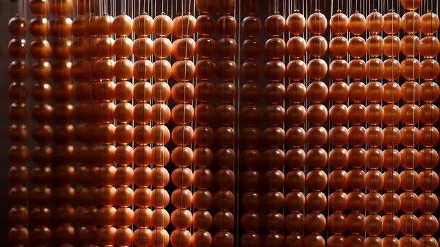 spinning amber beads creating hypnotic rhythmic pattern in closeup