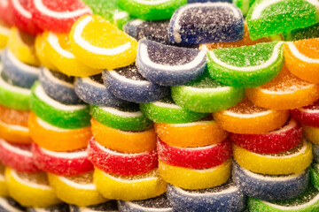 Close-up texture of a pile of green candies. Vibrant color and sugary surface details.

