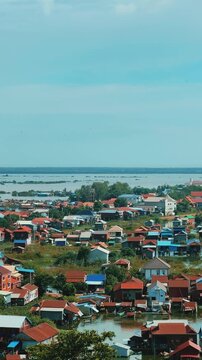 Viewpoint of a flooded fishing village near the Krahom Temple, Cambodia. From the mountain Krahom (Pnom Krom) overlooking the lake Tonlesap. Houses are built on high stilts. Rainy season. 4К