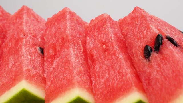 Row of fresh watermelon slices isolated on white background. Juicy red fruit snack close up.