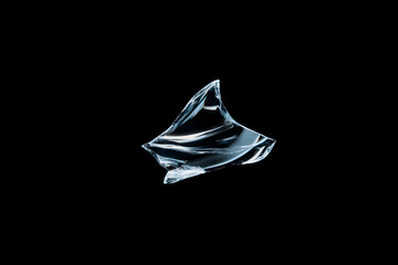 one clear sharp ice shard floating in dark space with dramatic light creating highlights and shadows abstract frozen element