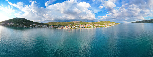 Wybrzeże Chorwacji w klimatycznym momencie pięknych chmur w okolicach Trogiru, wioska z lotu ptaka w lecie. © Franciszek