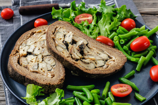 Finnish Kalakukko, fish pie on plate with veggies