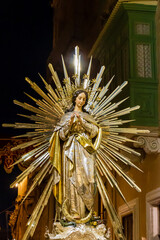 Statue of Virgin Mary With Radiant Golden Rays in Nighttime Street Procession