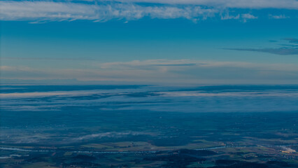 Fototapeta premium Blick auf die Landschaft von oben mit offenem Himmel und Wolken in der Dämmerung