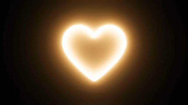 Pulsing golden heart animation with a warm glow. Abstract love symbol shining brightly on a black background