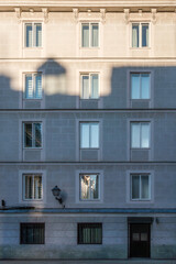 Fototapeta premium Residential building facade with windows and geometric shadows