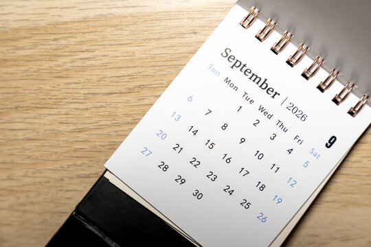 A detailed view of a calendar page for September 2026, showcasing days and dates amidst a wooden desk background. Ideal for planning, scheduling, and time management visuals.