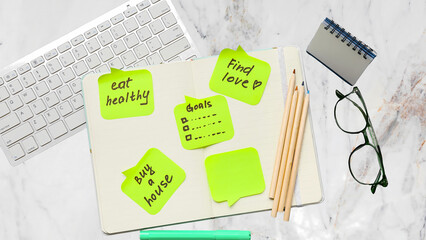 The word diet composed of colorful office supplies including pencils and pens on a blank white background with a notebook for business planning and school project design