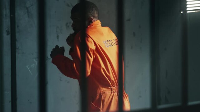 African American male inmate practicing shadow boxing in solitary prison cell