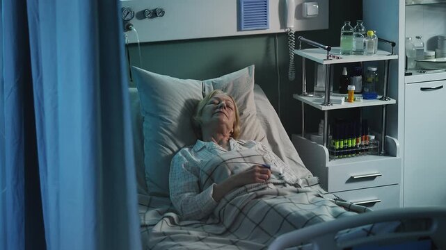Senior female patient with finger oximeter lying in intensive care unit bed