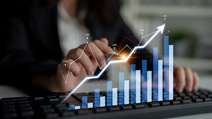 A business professional focuses on data analysis with digital graphs and charts illustrating financial growth trends while working on a computer keyboard. Scalp