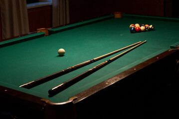 Calm Scene Of Cue Sticks And Balls, Quiet Pool Room With Focused Players And Soft Lighting