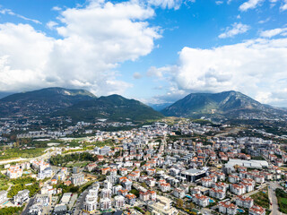 Expansive Aerial View of a Densely Developed Turkish Coastal Town Set Against the Backdrop of Large, Cloud-Capped Mountains