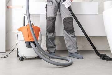 Cleaner Uses Vacuum Cleaner in Indoor Setting for Maintenance Tasks