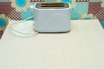 White toaster on a kitchen counter with colorful wall patterns in the background