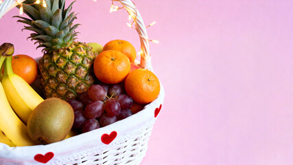 Fruit basket adorned with hearts and lights on pink background. Text space