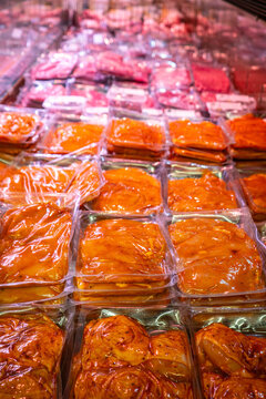 Slices of meats are for sale in the supermarket's refrigerated display.