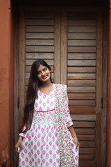 Fototapeta premium Portrait of a Smiling Young Woman in Traditional Floral Attire