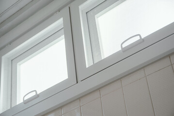 Small bathroom window letting in soft natural daylight, clean interior and minimal home design concept. Calm atmosphere of residential.