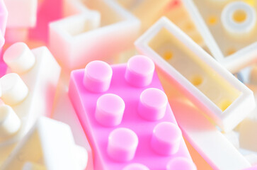 A collection of pastel pink and white building blocks are arranged in a soft focus, creating a...
