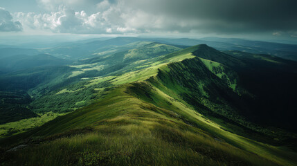 A stunning aerial view captures the lush green mountain range under a dramatic cloudy sky, showcasing the serene beauty of nature and the vast wilderness landscape.