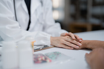 Doctor comforting patient holding hands during consultation