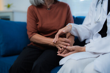 Fototapeta premium Doctor supporting senior patient by holding hands
