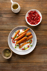 Top view of whole roasted carrots on plate