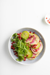Sliced winter pink radishes on plate top view