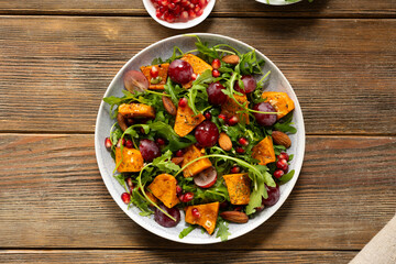 Top view of oven baked pumpkin salad wooden surface