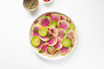 Overhead view of sliced winter pink radishes on plate