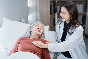 Obraz premium Doctor checking heart rate of senior patient during home visit