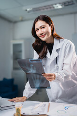 Asian doctor smiling and holding x-ray