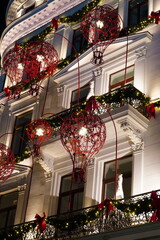 Beautiful historical building facade decorated for Christmas with wrought iron red balloons in center of Bucharest in 2025