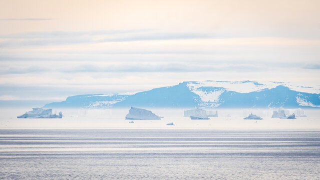 Close view of drifting icebergs in calm Arctic waters - Powered by Adobe