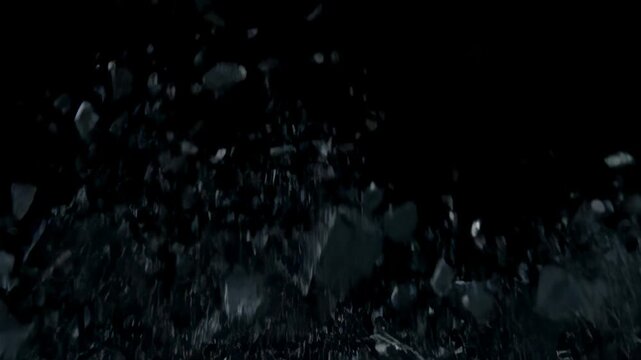 Wall shattering explosion with dark concrete breaking into pieces