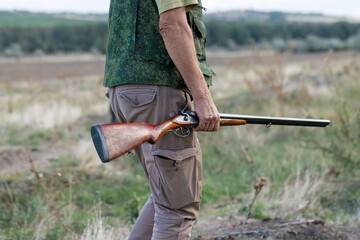 Close-up of a hunter's hand with a gun. Medium shot of a hunter with a weapon.