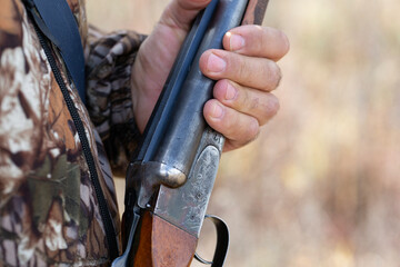 Close-up of a hunter's hand with a gun. Medium shot of a hunter with a weapon.