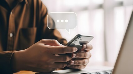 A person holding a smartphone and typing a message