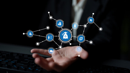 A businessman displays a digital interface filled with finance icons and data analytics symbols, illustrating modern investment and technology concepts in a dark setting. Tessel