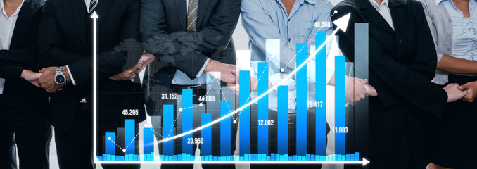 A professional business team stands confidently with a growth chart that signifies financial success and progress, illustrating commitment to goals and teamwork. Amity