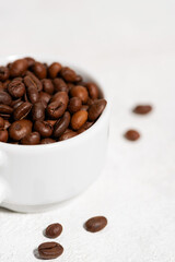 white cup with coffee beans on a white background, close-up, vertical