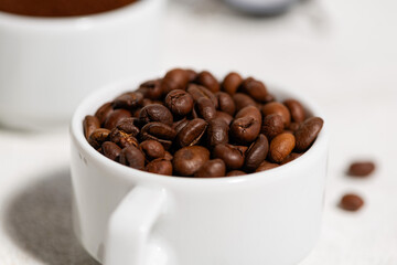 white cup with coffee beans on a white background, close-up